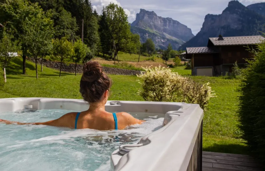 Spa extérieur devant un jardin et un paysage de montagne